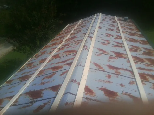 Rusted metal roof panels with new wood purlins before replacement — Storm Damage Roof Repair in Manville by Roofing Brothers