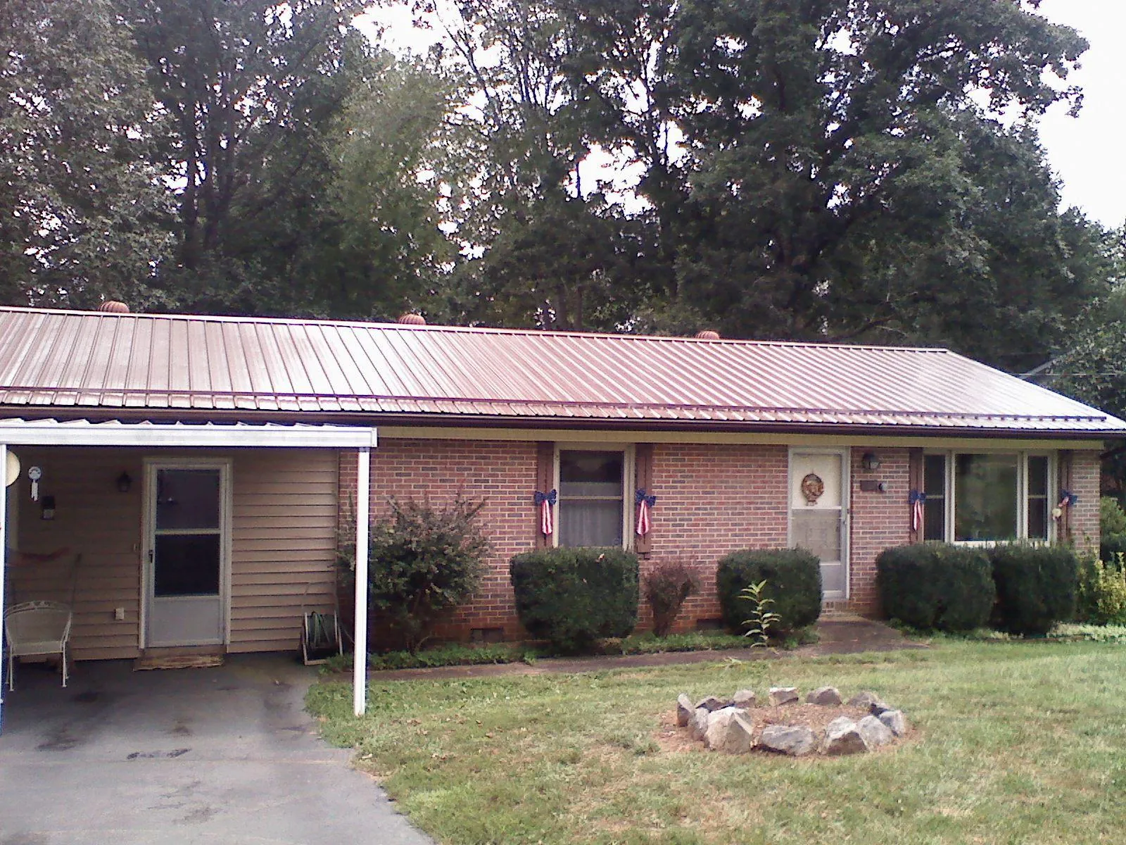 Bronze metal roof and carport on a brick ranch home — Roof Repair work by our crew in Manville